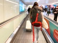 Rear view of female backpacker on moving walkway at the airport. Credit: istock.com/coldsnowstorm